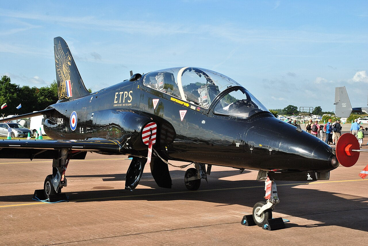 Close view of Hawk T1 XX154, showing its nose, cockpit, covered air intake and landing gear. Wing tips extend beyond the frame.