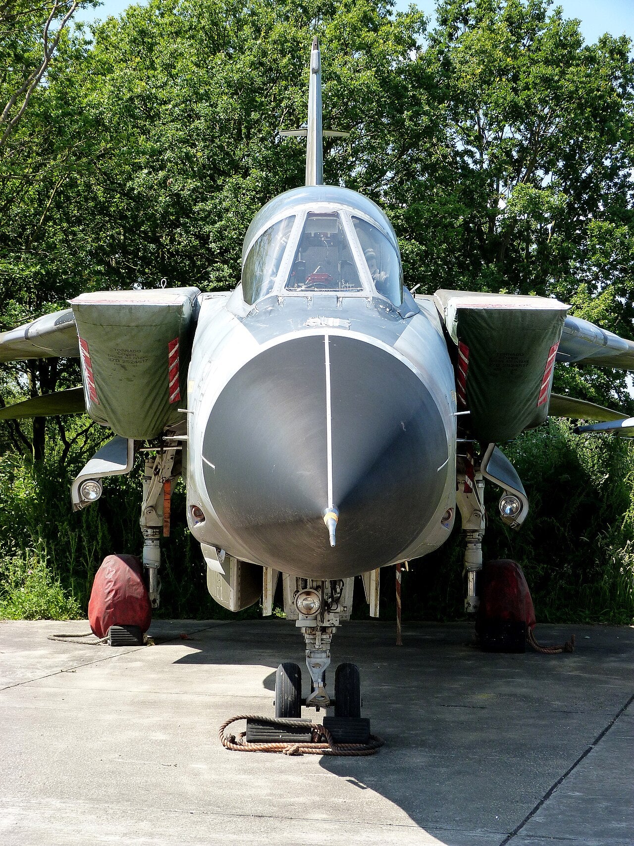 Front view of a Tornado GR1 at a museum, showing its nose, cockpit canopy, covered air intakes and landing gear.