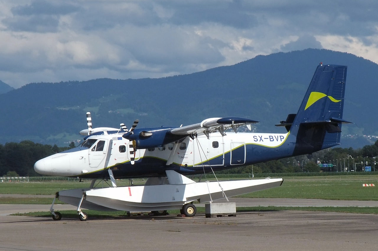 DHC-6 Twin Otter SX-BVP on floats, with a high wing and two propellers; a ground trolley sits beneath it.