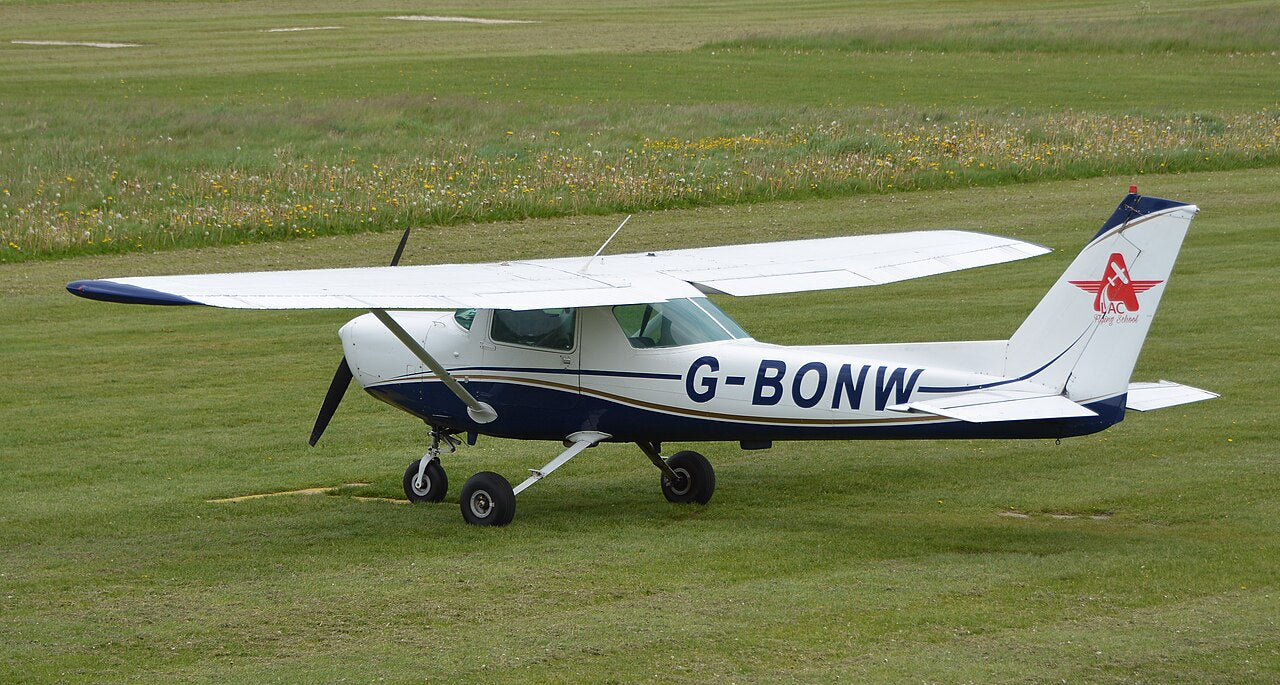 Cessna 152 G-BONW on grass, with a high wing, single propeller and fixed landing gear.